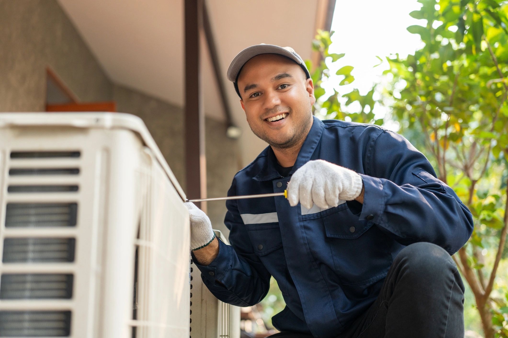 HVAC technician performing maintenance on outdoor AC unit
